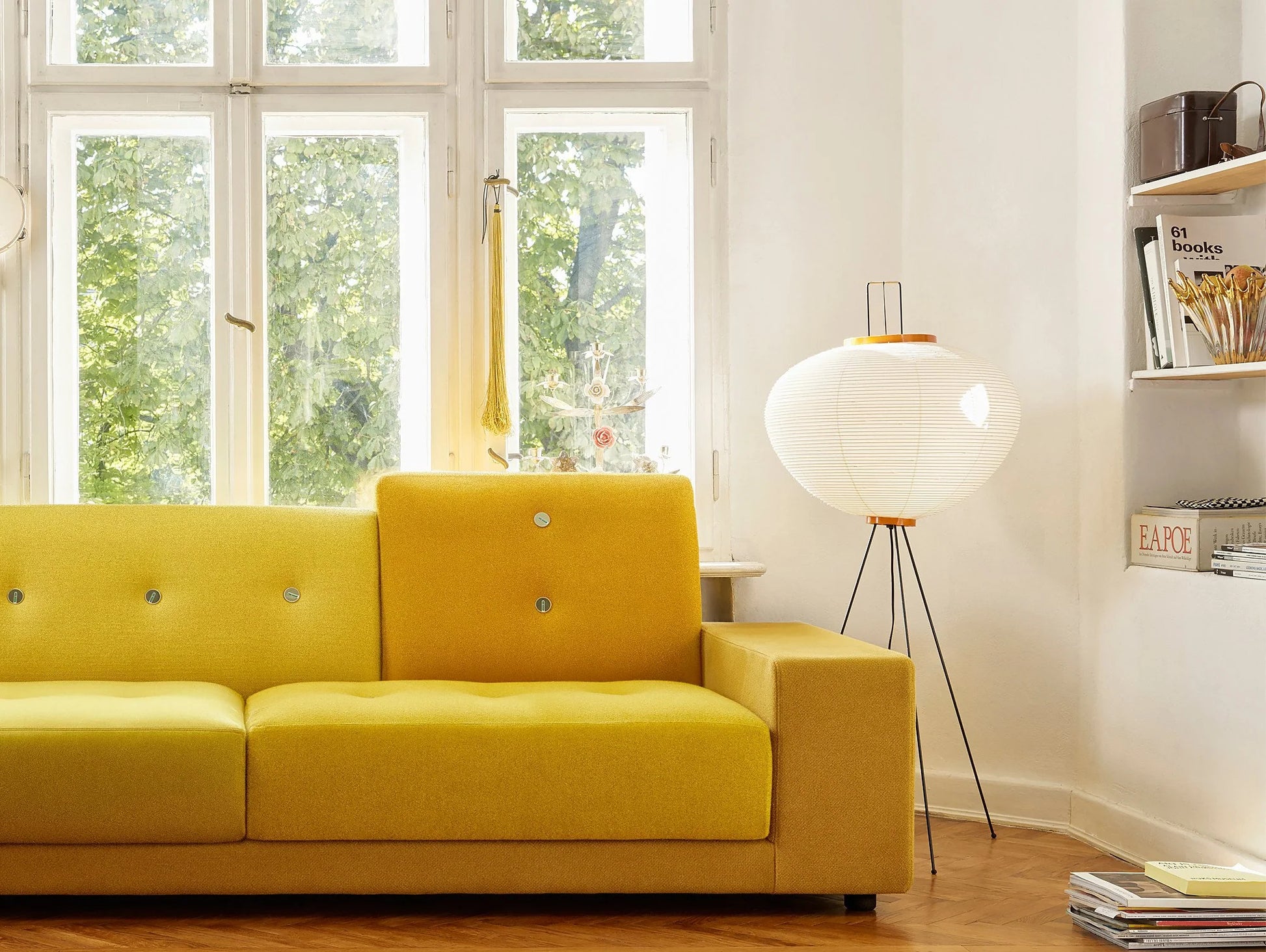 Akari standing lamp illuminating a minimalist living room.
