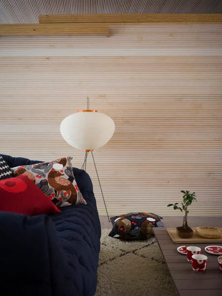 Handcrafted Japanese Akari lamp in a cozy bedroom setting.

